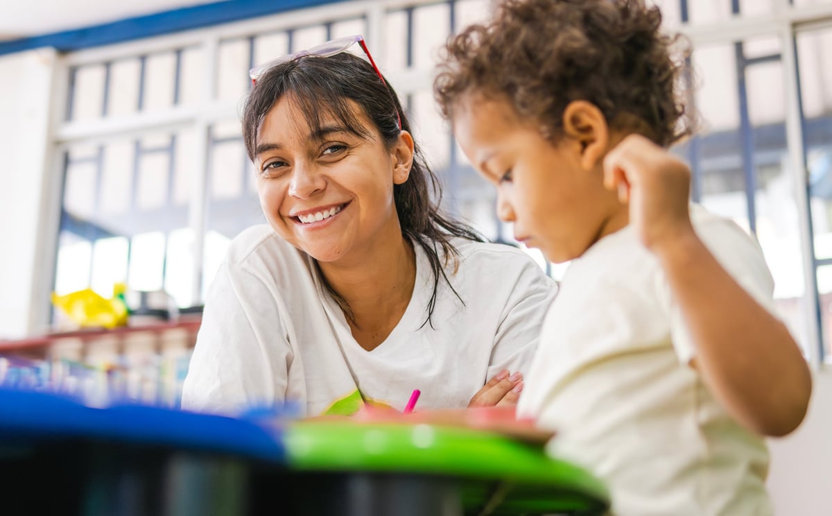 Happy teacher with child in preschool